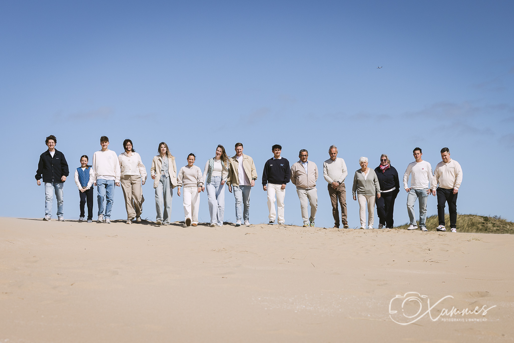 Grote familie tijdens een spontane familiefotoshoot op het strand en in de duinen